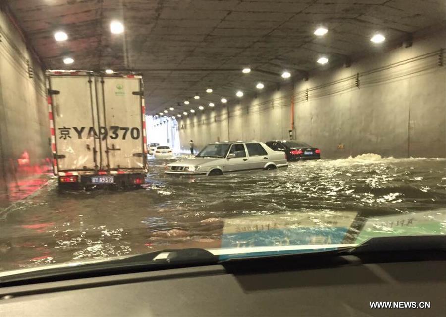 BEIJING, July 20, 2016 (Xinhua) -- Photo taken by a cellphone shows vehicles stranded in water at a flooded tunnel outside the Beijing West Railway Station in Beijing, capital of China, July 20, 2016. Beijing