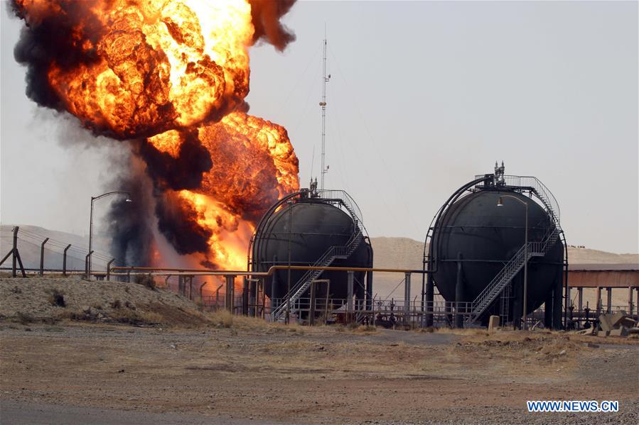 Huge fire rises from a fuel tank after gunmen stormed the oil field of Bai Hassan in northwest of the city of Kirkuk, Iraq, on July 31, 2016. Gunmen attacked two energy facilities in Iraq