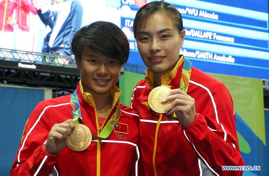 Chinese diving athletes Wu Minxia (R) and Shi Tingmao show gold medals at the awarding ceremony of women