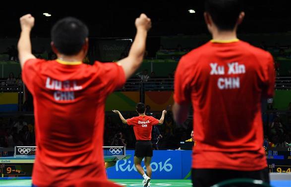 8月15日，中國隊教練劉國梁（左）和選手許昕慶祝張繼科（中）獲勝