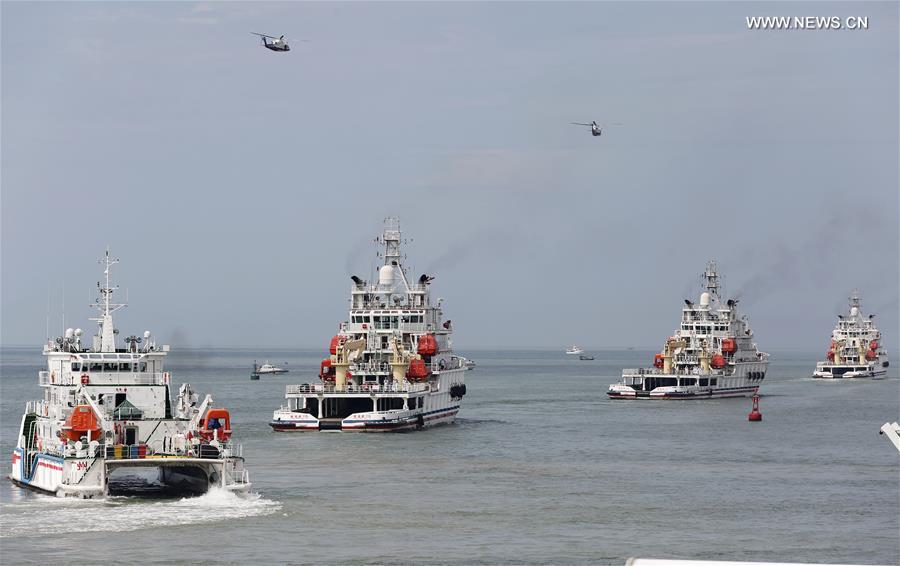 Rescue vessels and helicopters take part in an emergency rescue drill held at the sea area near Fenghuang island in Sanya, south China