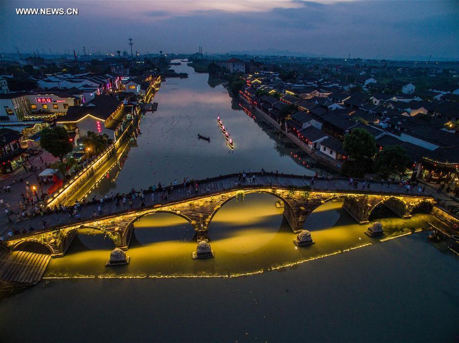 Tourists walk on the ancient Guangji Bridge in Tangqi Town, Hangzhou City, capital of east China