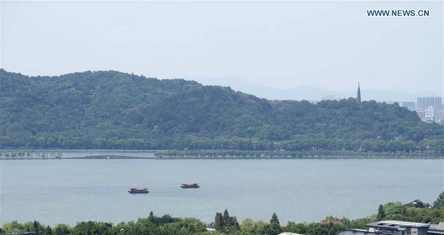 Photo taken on Aug. 27, 2016 shows two sightseeing boats on the West Lake in Hangzhou, capital city of east China