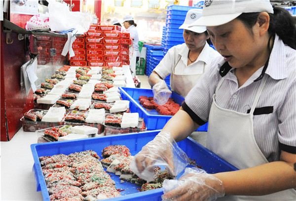 Staff members sell traditional Double Ninth cakes in Suzhou on the Double Ninth Festival, which falls on Oct 9, 2016. [Photo by Wang Jiankang/Asianewsphoto]