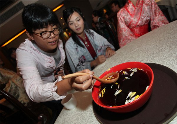 People taste chrysanthemum flower wine on the Double Ninth Festival. [File photo/Asianewsphoto]