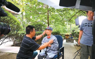 電視紀錄片《長征》總編導、製片人閆東（左）帶領工作人員採訪92歲的老紅軍萬曼琳