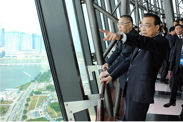 Premier Li Keqiang, right, climbs to the top of Macao Tower on Oct 10 accompanied by Macao’s Chief Executive Chui Sai On, left. [Photo/provided to chinadaily.com.cn]