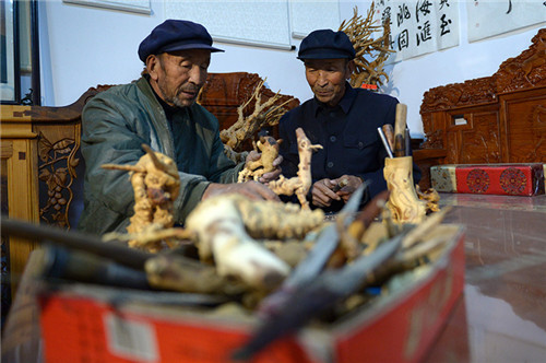 許志強（左）和許志剛在家裏製作根雕作品