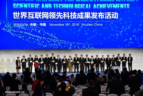 Representatives attending a release ceremony of world leading internet scientific and technological achievements pose for a group photo at the 3rd World Internet Conference in Wuzhen, east China