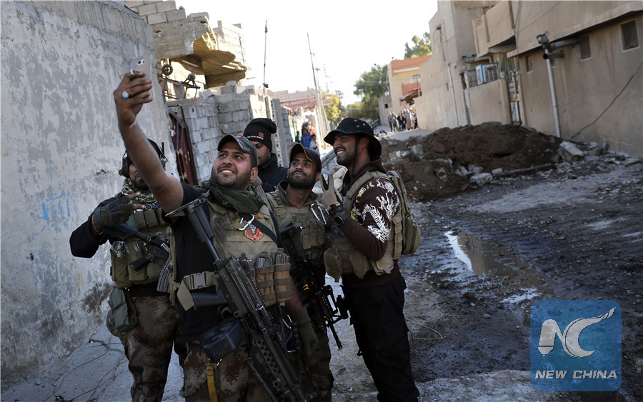 A soldier from the Iraqi Special Forces takes a selfie on a street in the Aden district of Mosul after troops almost entirely retook the area from Islamic State (IS) group jihadists on November 22, 2016. (AFP/Xinhua)