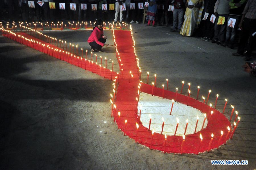 People light candles during an AIDS awareness program on the eve of World AIDS Day in Agartala, capital city of Tripura, India, Nov. 30, 2016. World AIDS Day is observed on Dec. 1 every year as millions of people in India are infected with HIV, the AIDS virus, but talking about the disease and sexual health issues in general is still largely taboo. (Xinhua/Stringer)