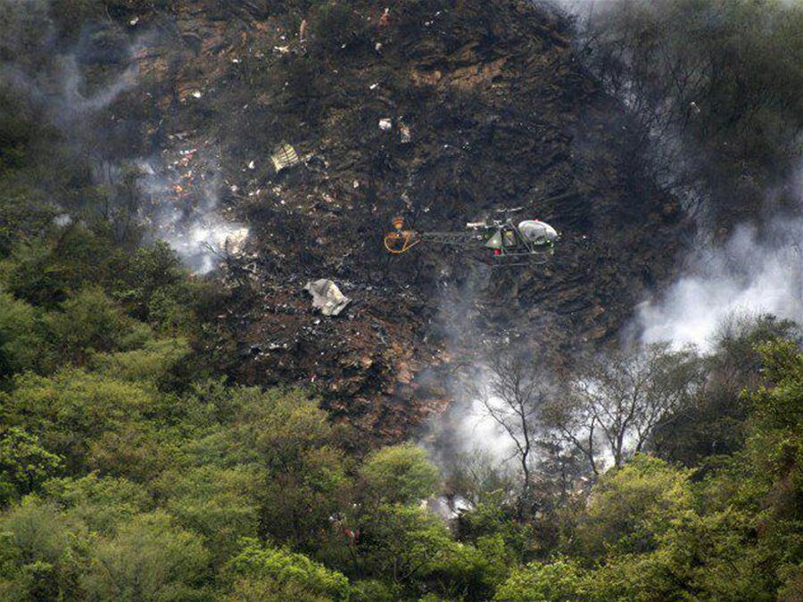 Photo taken on Dec. 7, 2016, shows a helicopter flying over the site of a plane crash in northwest Pakistan