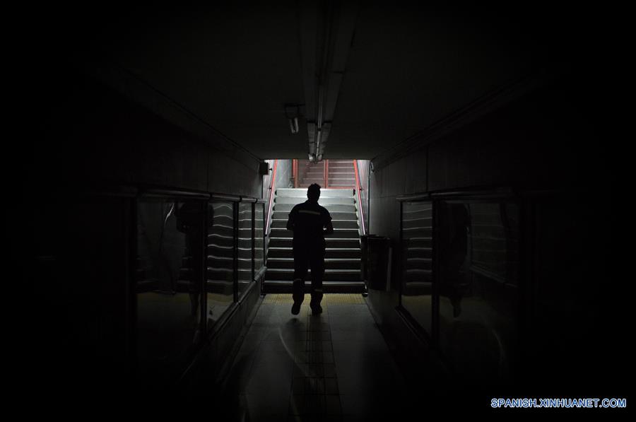 Imagen del 10 de diciembre de 2016 del escritor argentino, Enrique "Kike" Ferrari, dirigiéndose a cerrar la puerta de acceso de la estación Pasteur-AMIA de la línea B del Metro donde trabaja en el turno nocturno de limpieza, en Buenos Aires, Argentina. Ferrari, quien trabaja de 11 de la noche a cinco de la mañana en la estación, transmite su pasión por la escritura, por la que ha sido premiado y traducido al francés y el italiano, y la forma en que conjuga esa actividad con la limpieza. Escritor de novelas y cuentos del género negro premiado en Argentina, España, Francia y Cuba, admite que trabajar de noche le "dificultó la estructura". Me gusta escribir de mañana. Me despertaba temprano los sábados y domingos para escribir hasta el mediodía. Pero con la rutina de trabajar en la madrugada, el formato de escritura debió cambiar. Ferrari rescató las posibilidades que abre el hecho de estar despierto cuando la mayoría de los "porteños" duerme. "Así como molesta el horario, acompaña un poco la soledad, el silencio. Estar en un lugar en el que no hay nadie más que nosotros, haciendo un trabajo que requiere esfuerzo físico, me sirve", puntualizó. (Xinhua/Martín Zabala)