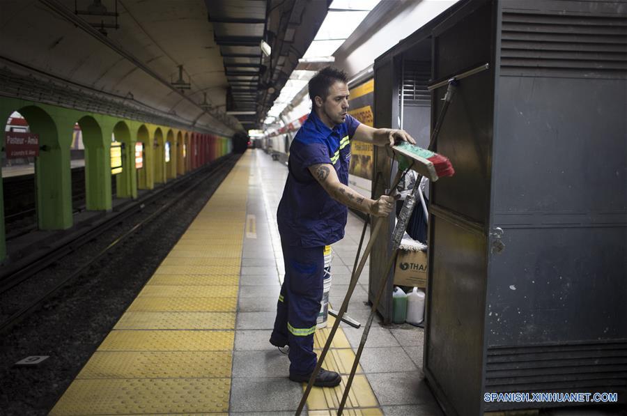 Imagen del 10 de diciembre de 2016 del escritor argentino, Enrique "Kike" Ferrari, preparando sus elementos de trabajo en la estación Pasteur-AMIA de la línea B del Metro donde trabaja en el turno nocturno de limpieza, en Buenos Aires, Argentina. Ferrari, quien trabaja de 11 de la noche a cinco de la mañana en la estación, transmite su pasión por la escritura, por la que ha sido premiado y traducido al francés y el italiano, y la forma en que conjuga esa actividad con la limpieza. Escritor de novelas y cuentos del género negro premiado en Argentina, España, Francia y Cuba, admite que trabajar de noche le "dificultó la estructura". Me gusta escribir de mañana. Me despertaba temprano los sábados y domingos para escribir hasta el mediodía. Pero con la rutina de trabajar en la madrugada, el formato de escritura debió cambiar. Ferrari rescató las posibilidades que abre el hecho de estar despierto cuando la mayoría de los "porteños" duerme. "Así como molesta el horario, acompaña un poco la soledad, el silencio. Estar en un lugar en el que no hay nadie más que nosotros, haciendo un trabajo que requiere esfuerzo físico, me sirve", puntualizó. (Xinhua/Martín Zabala)