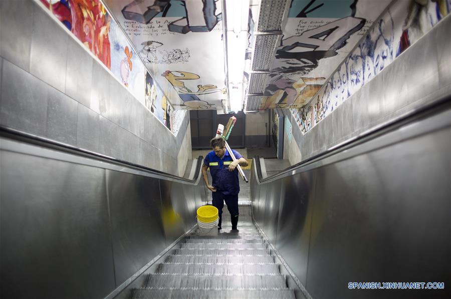 Imagen del 10 de diciembre de 2016 del escritor argentino, Enrique "Kike" Ferrari, trasladándose por medio de una escalera eléctrica con sus elementos de trabajo en la estación Pasteur-AMIA de la línea B del Metro donde trabaja en el turno nocturno de limpieza, en Buenos Aires, Argentina. Ferrari, quien trabaja de 11 de la noche a cinco de la mañana en la estación, transmite su pasión por la escritura, por la que ha sido premiado y traducido al francés y el italiano, y la forma en que conjuga esa actividad con la limpieza. Escritor de novelas y cuentos del género negro premiado en Argentina, España, Francia y Cuba, admite que trabajar de noche le "dificultó la estructura". Me gusta escribir de mañana. Me despertaba temprano los sábados y domingos para escribir hasta el mediodía. Pero con la rutina de trabajar en la madrugada, el formato de escritura debió cambiar. Ferrari rescató las posibilidades que abre el hecho de estar despierto cuando la mayoría de los "porteños" duerme. "Así como molesta el horario, acompaña un poco la soledad, el silencio. Estar en un lugar en el que no hay nadie más que nosotros, haciendo un trabajo que requiere esfuerzo físico, me sirve", puntualizó. (Xinhua/Martín Zabala)