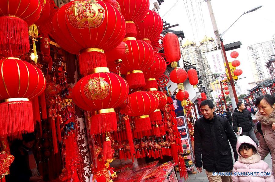 SHANGHAI, enero 15, 2017 (Xinhua) -- Personas caminan frente a decoraciones de Año Nuevo en el mercado Chenghuangmiao en Shanghai, en el este de China, el 15 de enero de 2017. Elementos tradicionales chinos son exhibidos en las calles de Shanghai para recibir el próximo Festival de Primavera o Año Nuevo Lunar del Gallo que se festeja este año el 28 de enero. (Xinhua/Chen Fei)