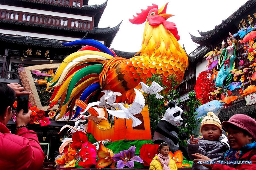 SHANGHAI, enero 15, 2017 (Xinhua) -- Personas posan frente a una linterna en forma de gallo en el mercado Chenghuangmiao en Shanghai, en el este de China, el 15 de enero de 2017. Elementos tradicionales chinos son exhibidos en las calles de Shanghai para recibir el próximo Festival de Primavera o Año Nuevo Lunar del Gallo que se festeja este año el 28 de enero. (Xinhua/Chen Fei)