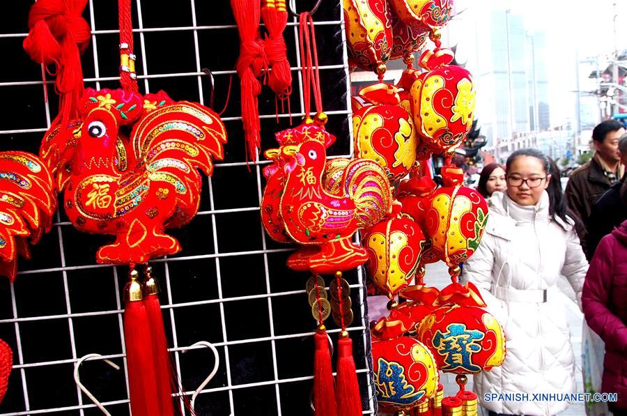 SHANGHAI, enero 15, 2017 (Xinhua) -- Personas caminan cerca de decoraciones de Año Nuevo en el mercado Chenghuangmiao en Shanghai, en el este de China, el 15 de enero de 2017. Elementos tradicionales chinos son exhibidos en las calles de Shanghai para recibir el próximo Festival de Primavera o Año Nuevo Lunar del Gallo que se festeja este año el 28 de enero. (Xinhua/Chen Fei)