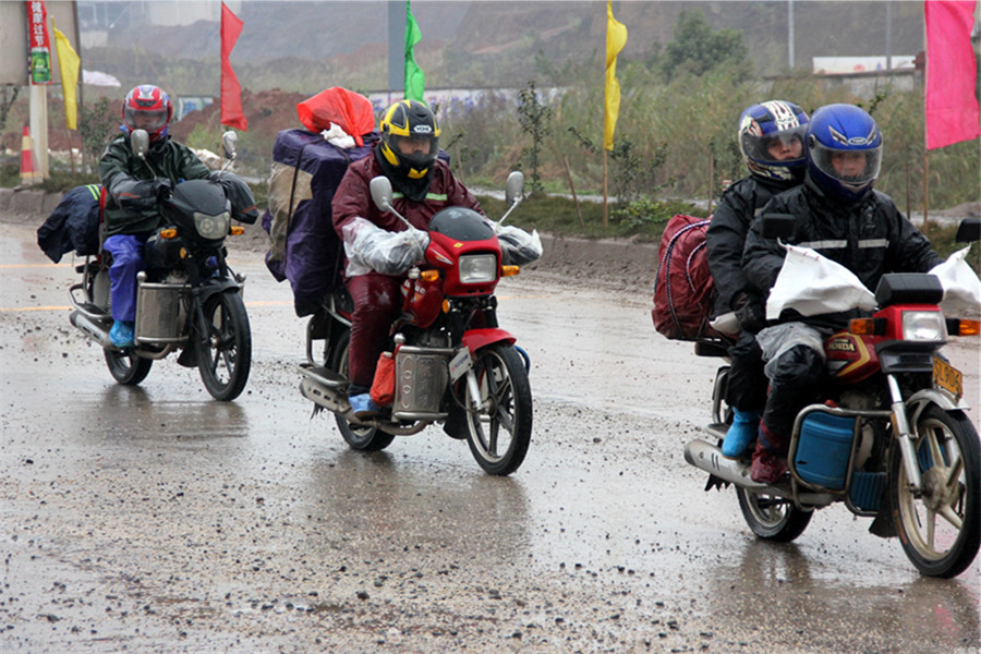 En el tramo del distrito de Tengxian de la ciudad china de Wuzhou, los trabajadores migratorios acuden a su tierra natal desafiando el viento y la lluvia para reunirse con los familiares