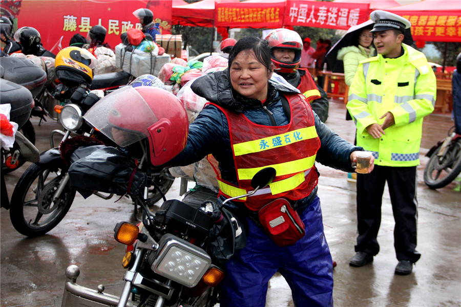 Sacudiendo la lluvia del casco, la abuela Zhang entró en  la estación para descansar