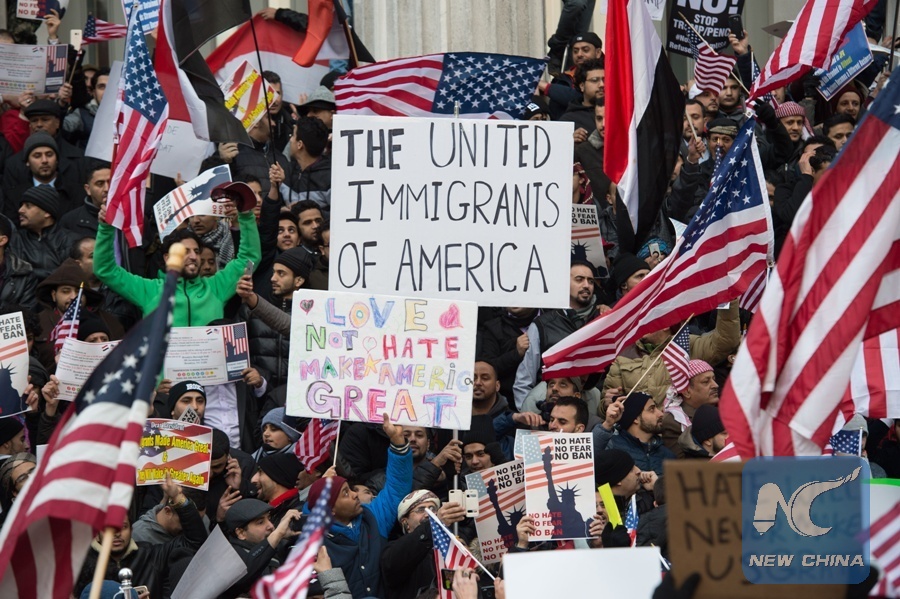 People rally with flags at Brooklyn Borough Hall as Yemeni bodega and grocery-stores shut down to protest U.S. President Donald Trump