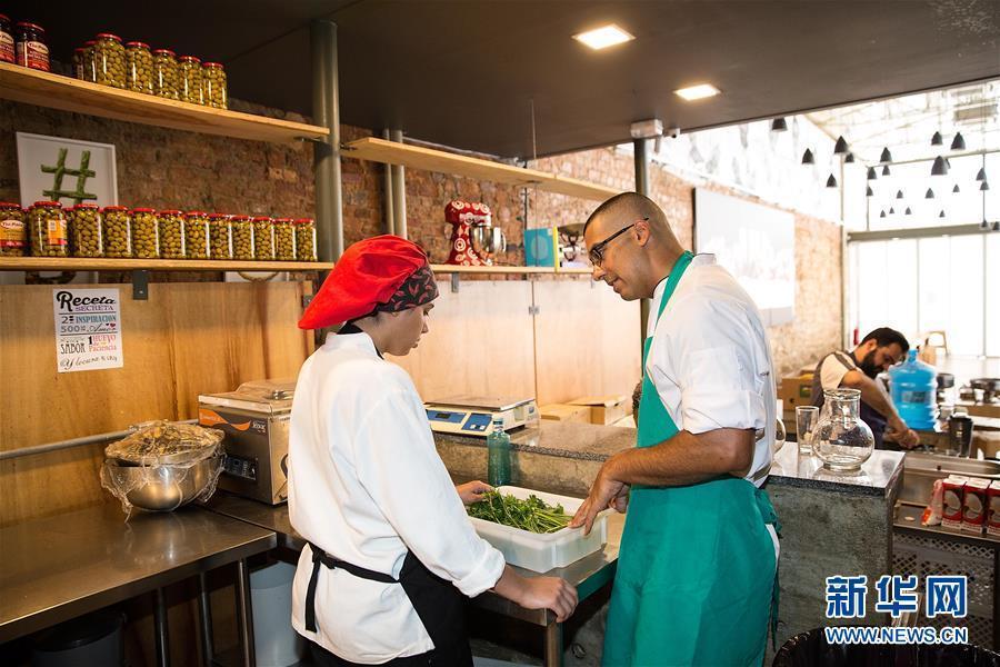 El chef ejecutivo del día habla con un alumno cuando prepara la cena