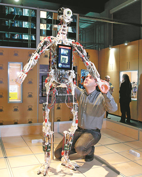 A technician adjusts an android on Tuesday for a robot exhibition at the Science Museum in London. The show features an array of robots whose faces range from futuristic to lifelike. ALASTAIR GRANT / AP