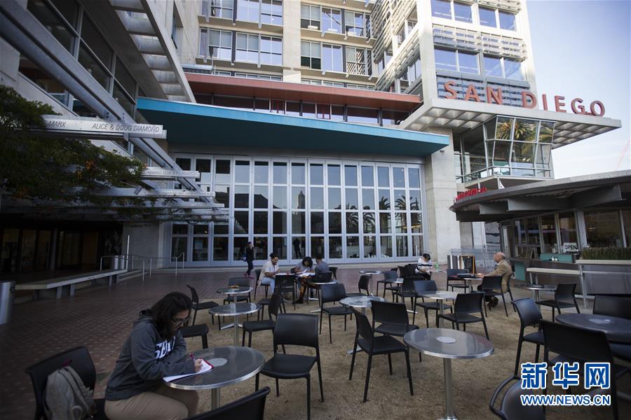 Jaime repasa lo enseñado en la clase sentada en la plaza de la biblioteca de su universidad