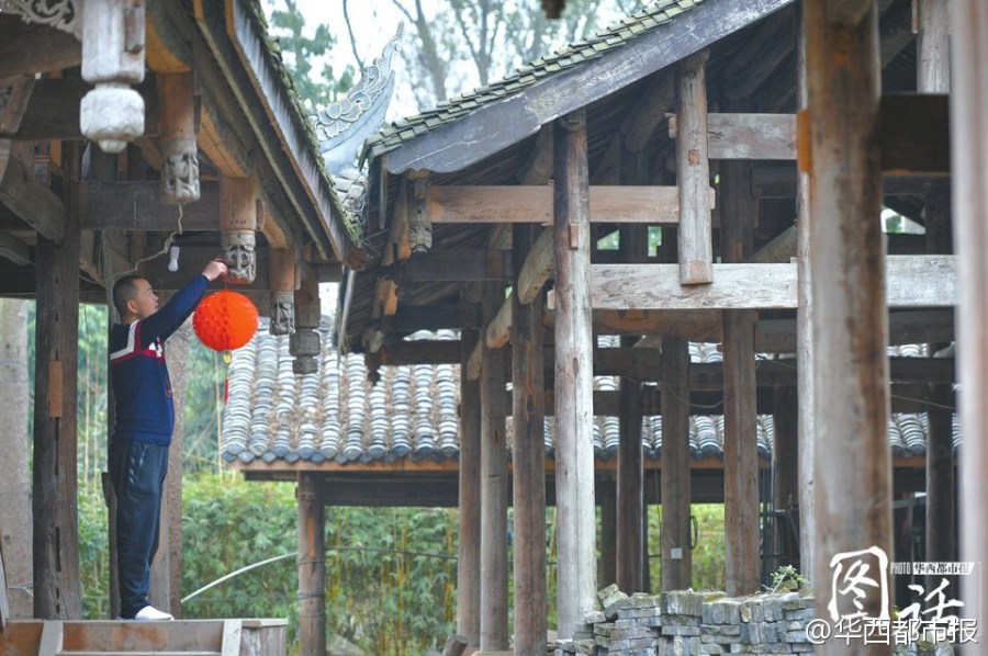 En el Inicio de la Primavera, Li Xiaochun cuelga un farol rojo a una casa antigua y espera que pueda tocar el zheng cantando bajo el techo para experienciar la vida de los antepasados en el futuro