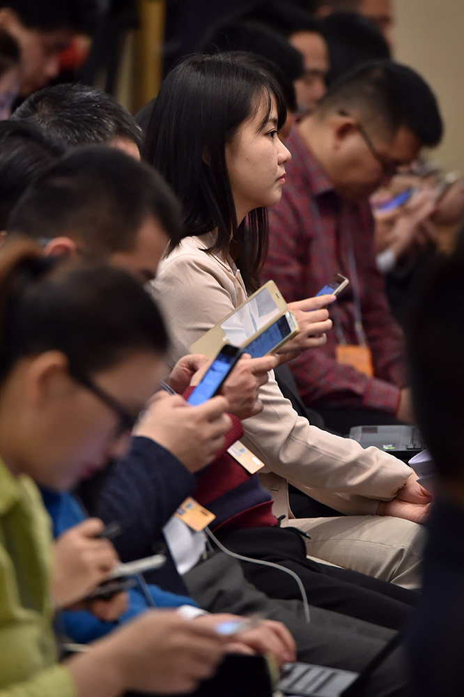 3月7日，在記者會上，認真聽會的女記者。