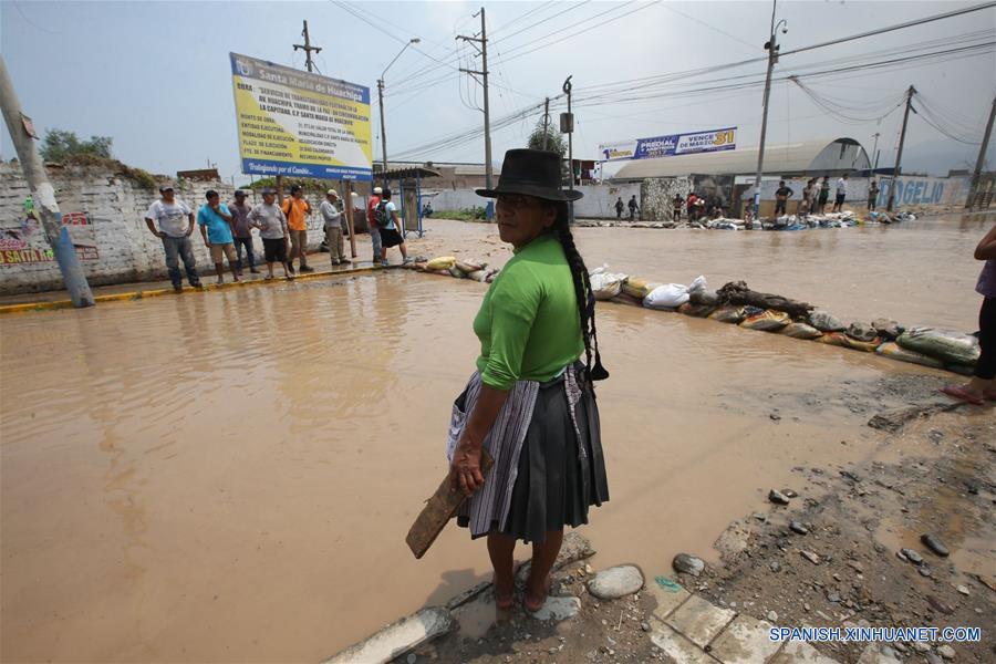 LIMA, marzo 16, 2017 (Xinhua) -- Personas observan una calle inundada luego del desborde del río Rímac, en un sector de Huachipa, al este de Lima, Perú, el 16 de marzo de 2017. Las lluvias intensas provocadas por el Fenómeno El Niño costero afectan Lima desde el mediodía del miércoles. Las adversas condiciones climáticas, con lluvias torrenciales, siguen afectando el desarrollo de varias regiones peruanas, lo que ha obligado a las autoridades a estar en permanente "alerta roja" para atender las necesidades de las poblaciones. (Xinhua/Juan Carlos Guzmán/ANDINA)