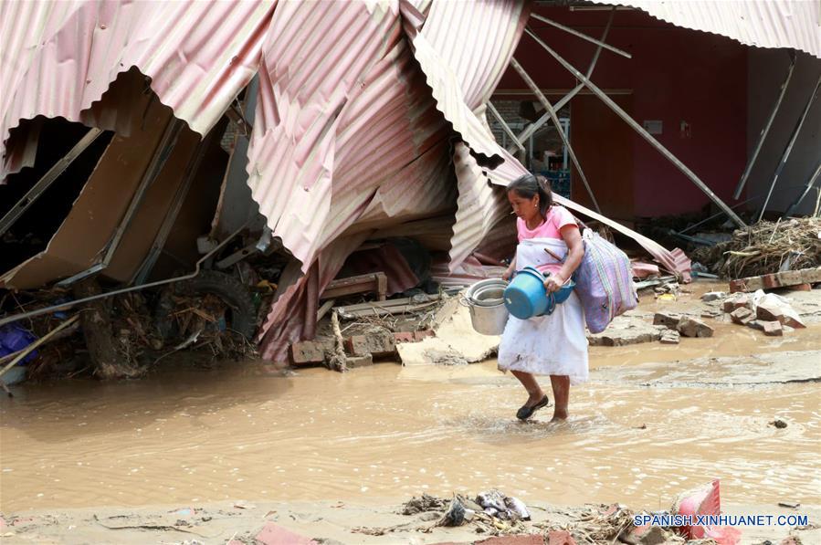 LIMA, marzo 20, 2017 (Xinhua) -- Una mujer camina en medio de un camino inundado luego de los huaicos en Huachipa, provincia de Lima, Perú, el 20 de marzo de 2017. El Centro de Operaciones de Emergencia Nacional (COEN) de Perú confirmó que hasta el lunes 75 personas han fallecido desde diciembre pasado, 263 resultaron heridas y 30 más están desaparecidas a causa del fenómeno climático "El Niño" en la zona costera. La entidad indicó en un comunicado que "El Niño", que apareció débil en diciembre pasado y se agudizado en marzo, ha traído consigo 627,048 afectados en 11 regiones del país sudamericano, así como 100,169 damnificados. (Xinhua/Norman Córdova/ANDINA)