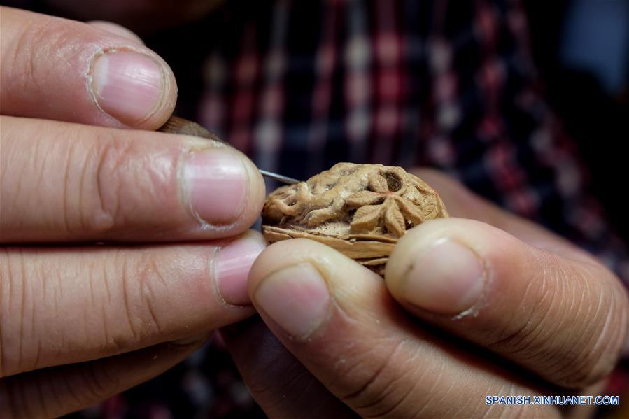 ANHUI, marzo 20, 2017 (Xinhua) -- El artista Ma Yongbing talla una figura en un hueso de durazno en Xuancheng, provincia de Anhui, en el este de China, el 20 de marzo de 2017. El los últimos 25 años, Ma Yongbing, ha creado más de un millar de piezas de esculturas en huesos de durazno. Las creaciones de Ma destacan principalmente las historias chinas tradicionales, arquitecturas, paisajes, entre otros. (Xinhua/Meng Dingbo)