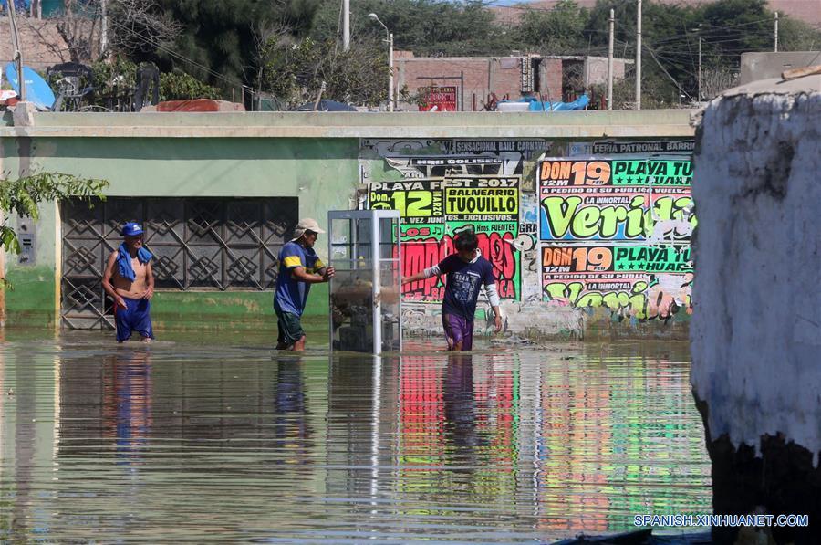 HUARMEY, marzo 22, 2017 (Xinhua) -- Personas caminan a través del agua de la inundación en la ciudad de Huarmey, en el sur de la región Ancash, Perú, el 22 de marzo de 2017. Las fuertes lluvias que se registran en Perú persistirán durante al menos dos semanas en 12 regiones del país sudamericano, informó el martes el Centro de Operaciones de Emergencia Nacional (COEN). De acuerdo con la entidad, las regiones más afectadas continuarán siendo Tumbes, Piura, Lambayeque, La Libertad y Ancash en el noroeste, Lima en el centro-este, Ica, Arequipa, Moquegua y Tacna en el sur, y Huancavelica y Ayacucho en el sureste. (Xinhua/Vidal Tarqui/ANDINA)