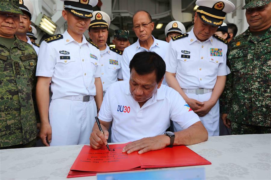 Philippine President Rodrigo Duterte signs a guest book while visiting China