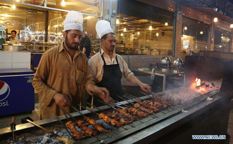 Chefs make kebabs of chicken and mutton at a stall along a food street in Pakistan