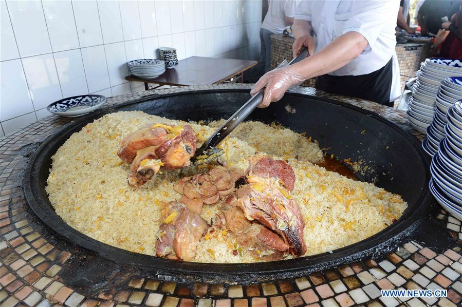 A chef cooks traditional Uzbek Plov (Lamb Pilaf) at a park in Toshkent, the capital of Uzbekistan. [Photo/Xinhua]