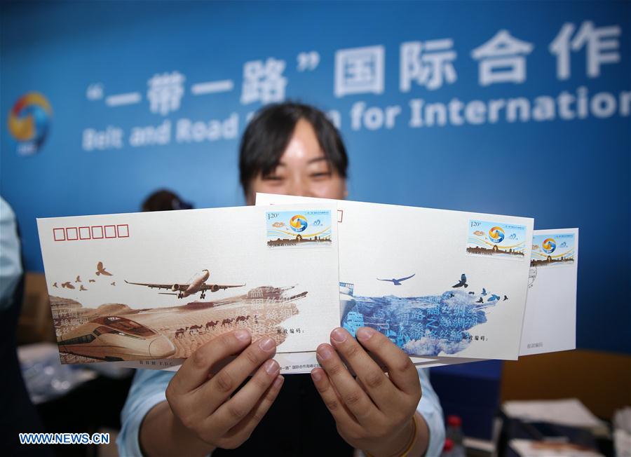 A staff member shows commemorative first-day covers featuring the Belt and Road Forum (BRF) for International Cooperation at the China National Convention Center in Beijing, capital of China, May 14, 2017.The Belt and Road Forum (BRF) for International Cooperation opened in Beijing on Sunday. (Xinhua/Cai Yang)