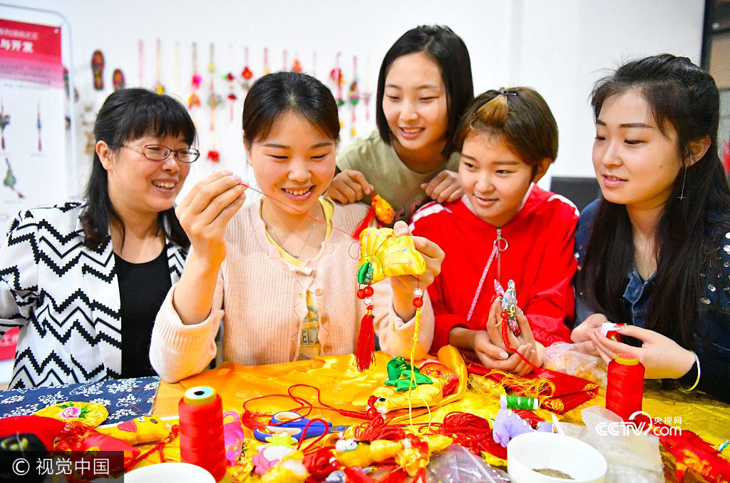 Students from Bozhou College learn to make sachets under the instruction of their teacher Yu Caixia(1st,L)in Zhumeng Community, Bozhou of Anhui Province, May 23, 2017.