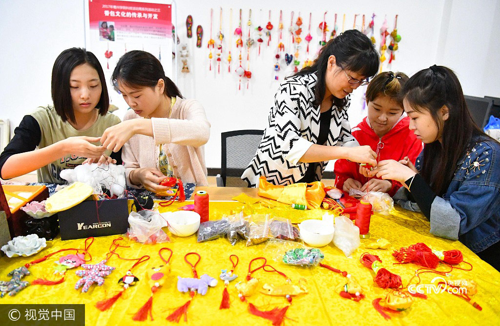 Students from Bozhou College learn to make sachets under the instruction of their teacher Yu Caixia(3rd,L) in Zhumeng Community, Bozhou of Anhui Province, May 23, 2017.