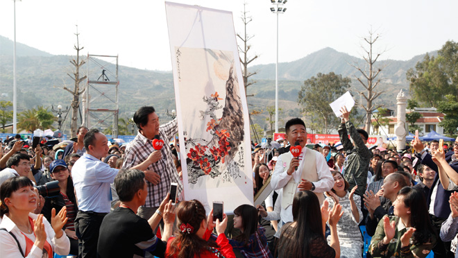 圖一：《鄉約》在攀枝花市東區錄製現場，當地藝術家向主持人展示書畫作品