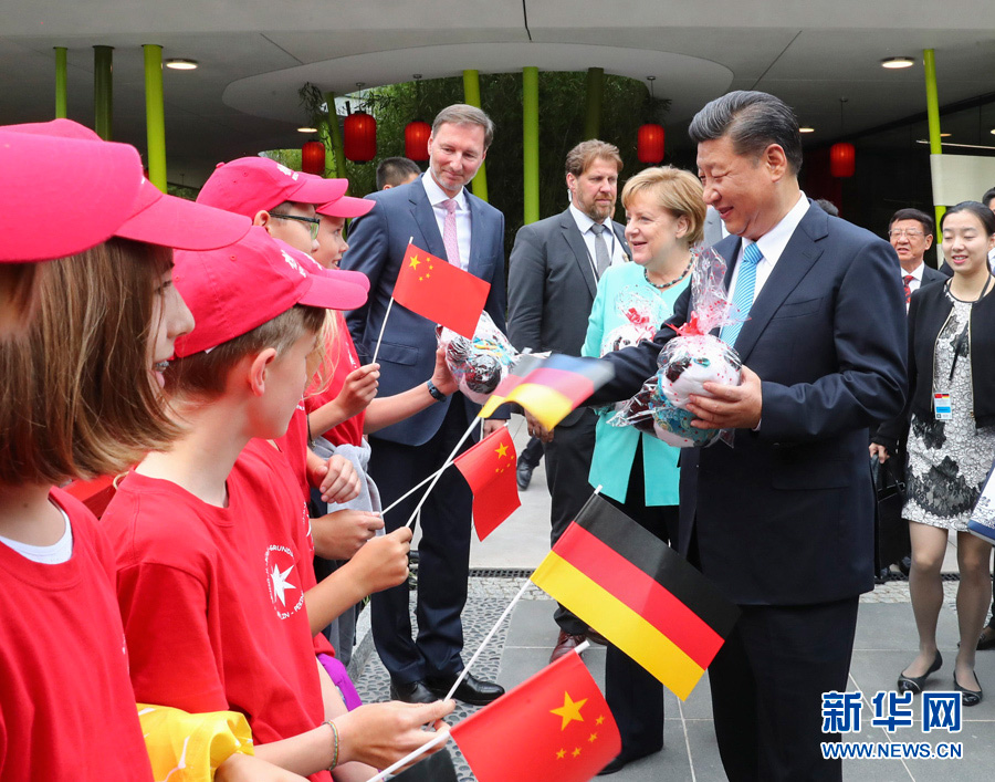 7月5日，國家主席習近平同德國總理默克爾共同出席柏林動物園大熊貓館開館儀式。這是習近平向現場的孩子們贈送大熊貓毛絨玩具。-新華社記者謝環馳-攝
