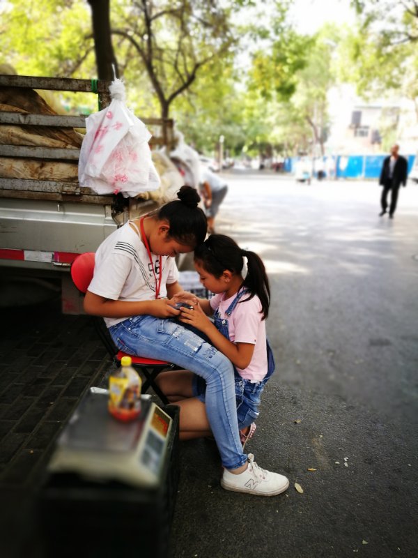 Two girls help their family sell fruit. Many people here prefer to buy fruit and vegetables from local farmers’ trucks, since they are considered to be cheaper and fresher than products in super markets. 