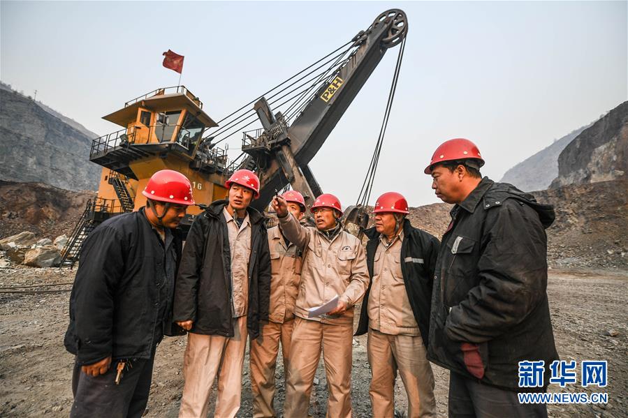 11月3日，郭明義（右三）在鞍鋼礦業集團齊大山鐵礦採場與工友交流制定修路方案。