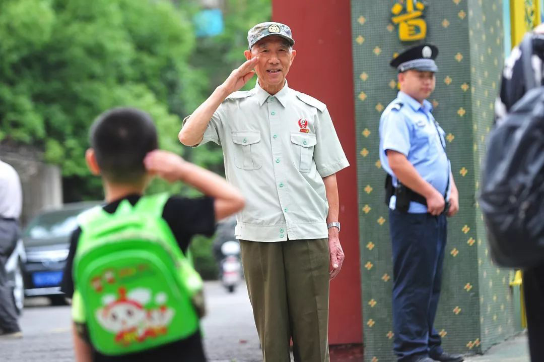 79歲的李國發給入園的孩子敬禮  記者彭年 攝