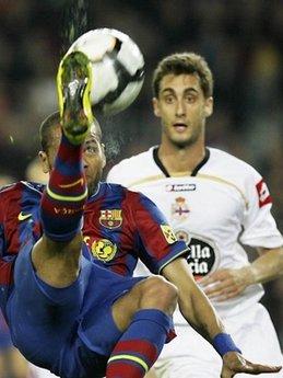 Battle for the ball : Barcelona's Brazilian defender Daniel Alves (L) fight for the ball with Deportivo's defender Adrian Lopez (R) during a Spanish League football match at the Camp Nou Stadium in Barcelona. Barca won 3-0.(AFP/Josep Lago)