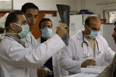 Physicians wear face masks at the at al-Shifa hospital in Gaza City Sunday, Dec. 6, 2009 after the Ministry of Health in Gaza confirmed on Sunday that five residents have been infected with the swine flu. The World Health Organization says it is monitoring the situation in the blockaded territory, where health care is shabby and there are a shortage of vaccines for health workers. (AP Photo/Hatem Moussa) 