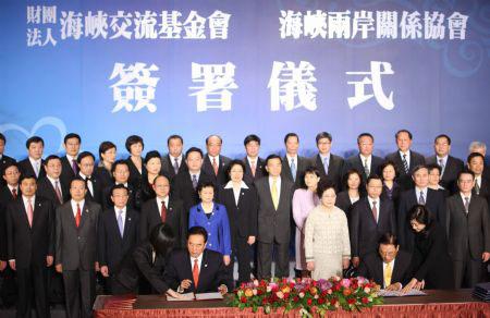 Chen Yunlin (L, front), president of the mainland's Association for Relations Across the Taiwan Straits (ARATS), and Chiang Pin-kung (R, front), chairman of Taiwan's Straits Exchange Foundation (SEF), sign agreements in Taichung, southeast China's Taiwan, Dec. 22, 2009. Chinese mainland and Taiwan negotiators reached three agreements on fishing, farm produce and standards measuring on Tuesday.(Xinhua/Yuan Man)