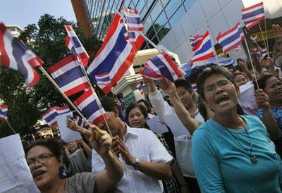 Pro-government protesters hold national flags as they gather near anti-government protesters to show their support to Prime Minister Abhisit Vejjajiva in Bangkok, Thailand Wednesday, April 21, 2010. (AP Photo/Vincent Yu)