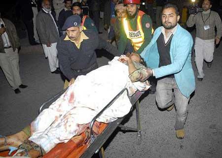 People rush an injured person to a local hospital in Lahore, Pakistan on Monday, Dec. 7, 2009.(Xinhua/AP Photo)